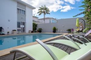 una piscina con sedie a sdraio accanto a un edificio di Snooker House a Ponta Delgada