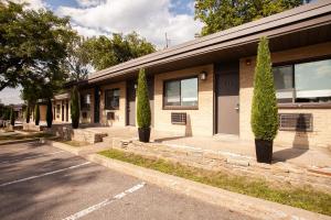 un bâtiment avec des arbres en face d'une rue dans l'établissement Motel Newstar Laval, à Laval