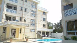 - un bâtiment avec une piscine en face dans l'établissement Pavilion Holiday Resort, à Bamburi