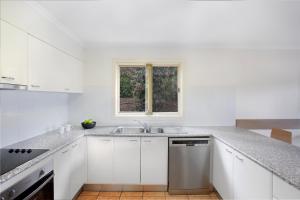 a white kitchen with a sink and a window at BreakFree Aanuka Beach Resort in Coffs Harbour