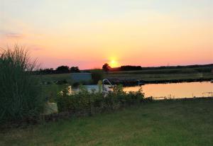 een zonsondergang boven een waterlichaam met zonsondergang bij Landhaus Fünfseen in Funfseen