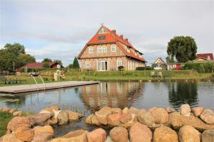 een groot huis met een vijver ervoor bij Landhaus Fünfseen in Funfseen