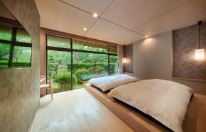 - une chambre avec un lit et une grande fenêtre dans l'établissement Awazuonsen Kitahachi, à Komatsu