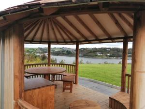 - un kiosque en bois avec une table et un banc dans l'établissement Marina views, Kinsale, Exquisite holiday homes, sleeps 20, à Kinsale