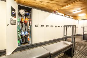 a bench in a hockey locker room with skis at Sertorelli Sporthotel in Breuil-Cervinia