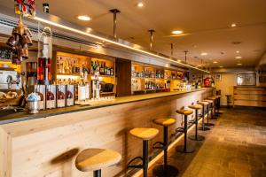 a bar with a row of stools in a room at Sertorelli Sporthotel in Breuil-Cervinia