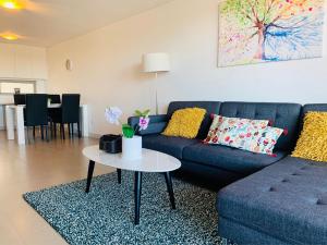 een woonkamer met een blauwe bank en een tafel bij Beautiful Home close to Shopping Mall and Train Hornsby in Hornsby