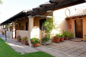 una casa con piante in vaso su un lato di La Fontana Dei Desideri ad Alghero