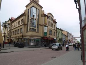 ein Gebäude in einer Stadtstraße mit Menschen und Autos in der Unterkunft Atrium Hotel in Iwano-Frankiwsk