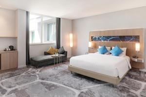 A bed or beds in a room at Novotel Jakarta Mangga Dua Square