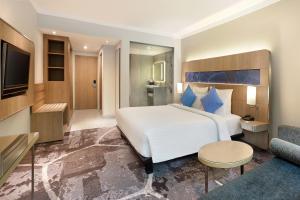 A bed or beds in a room at Novotel Jakarta Mangga Dua Square