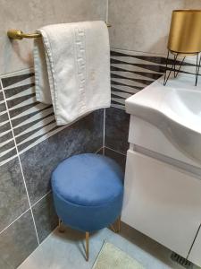 un taburete azul en un baño junto a un lavabo en Portobella Airport Aparthotel - Self Check in, en Otopeni