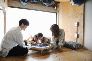 高松市にあるSUNNY DAY HOSTELの部屋のテーブルで遊ぶ家