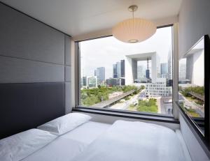 Una cama o camas en una habitación de citizenM Paris La Défense