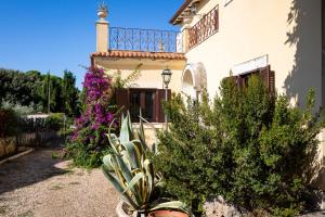 a house with a balcony and some plants and flowers at Appartamento Villa Matone in Grottaferrata