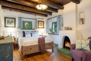 1 dormitorio con 1 cama y chimenea en Inn of the Turquoise Bear, en Santa Fe