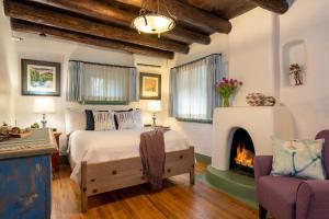 1 dormitorio con 1 cama y chimenea en Inn of the Turquoise Bear, en Santa Fe