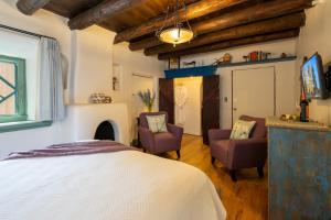 1 dormitorio con 1 cama y 2 sillas en Inn of the Turquoise Bear, en Santa Fe