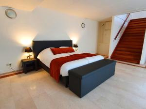 um quarto com uma cama grande com lençóis vermelhos e brancos em Bed & Breakfast Trouwborst em Rhenen