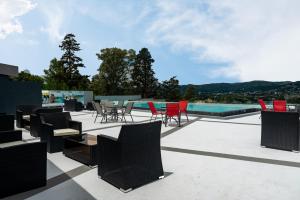 um pátio com cadeiras e mesas e uma piscina em Domus Lake Resorts em Villa Carlos Paz