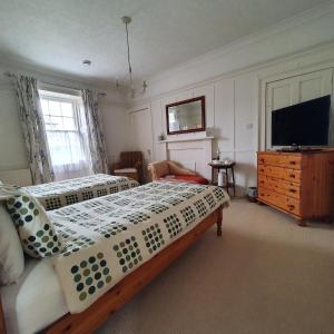 een slaapkamer met 2 bedden en een flatscreen-tv bij Moraybank Bed & Breakfast in Elgin