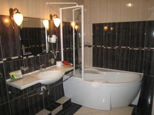 ein Badezimmer mit einer Badewanne, einem Waschbecken und einer Badewanne in der Unterkunft Atrium Hotel in Iwano-Frankiwsk