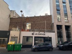 a store with cars parked in front of a building at Le Coffice Auberge de Jeunesse in Paris