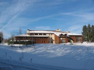 een groot gebouw met sneeuw op de grond voor de deur bij Auberge de Jeunesse HI Annecy in Annecy