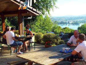 un gruppo di persone seduti intorno a un tavolo da picnic in legno di Auberge de Jeunesse HI Annecy ad Annecy