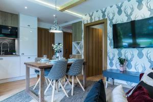 comedor con mesa y sillas en Rezydencja Sobiczkowa Apartamenty, en Zakopane