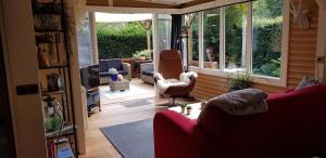 a living room with a red couch and a television at vakantiehuis op de veluwe in Wolfheze