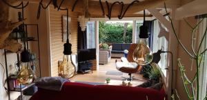 a living room with a red couch and a chair at vakantiehuis op de veluwe in Wolfheze