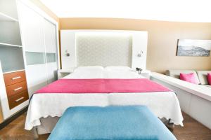 een slaapkamer met een groot bed met rode en blauwe lakens bij Hotel Beatriz Playa & Spa in Puerto del Carmen