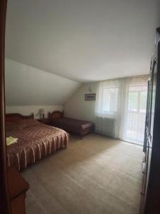 a bedroom with a bed in a room with windows at Pensiunea Casa Domniței Sucevița in Suceviţa