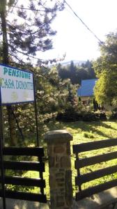 a sign next to a fence next to a house at Pensiunea Casa Domniței Sucevița in Suceviţa