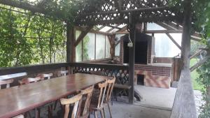 a wooden table and chairs on a patio at Pensiunea Casa Domniței Sucevița in Suceviţa