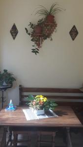 a wooden table with a flower arrangement on it at Pensiunea Casa Domniței Sucevița in Suceviţa