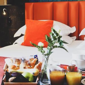 una mesa con una bandeja de comida en una cama en Hotel Verlaine, en Cannes