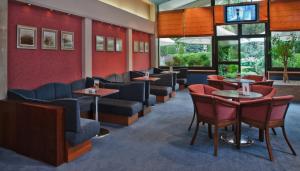 a waiting room with couches and tables and windows at Booking Hotel Crown Piast & Spa in Kraków