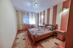 een slaapkamer met een bed en een gestreepte muur bij Lux Apartman Cvetkovic in Kraljevo