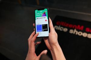 une personne tenant un téléphone portable avec les mains dans l'établissement citizenM Paris Charles de Gaulle Airport, à Roissy-en-France