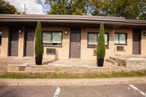 un bâtiment avec deux arbres devant lui dans l'établissement Motel Newstar Laval, à Laval