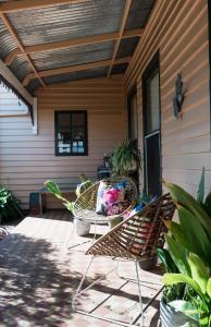 eine Terrasse mit einem Tisch und Stühlen auf einer Veranda in der Unterkunft Merrijig Inn in Port Fairy