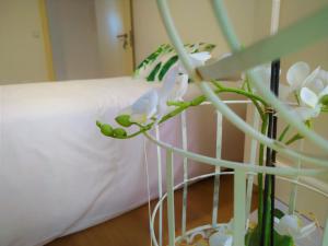 - un lit blanc avec des fleurs blanches dans une chambre dans l'établissement Casa do Castelo Ourém, à Ourém