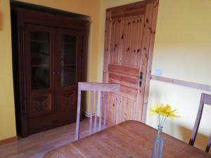 une table en bois avec un vase sur une table et une porte dans l'établissement FeWo Gutendorf, à Bad Berka