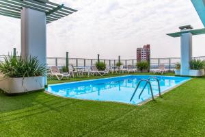 una piscina sul tetto di un edificio con erba verde di Hotel Cecilia ad Asunción