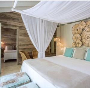 een slaapkamer met een groot wit bed en een baldakijn bij Mahona Boutique Hotel in Las Terrenas