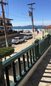 a green bench on a sidewalk next to a street at Cond. Hotel Âncora em frente Praia do Peró in Cabo Frio