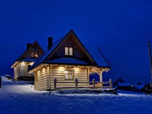 uma casa com luzes na frente à noite em Domki w Mizernej 38, Czorsztyn , Pieniny, Szczawnica em Kluszkowce