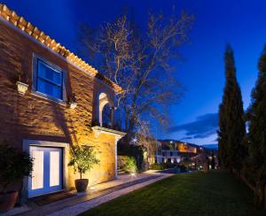 een gebouw met een boom in een tuin 's nachts bij Quinta do Vallado - Douro Wine Hotel in Peso da Régua